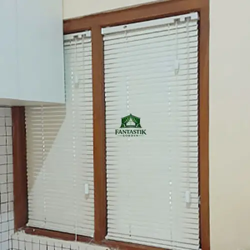 Horizontal blind kayu warna natural di ruang tamu dengan pencahayaan hangat.